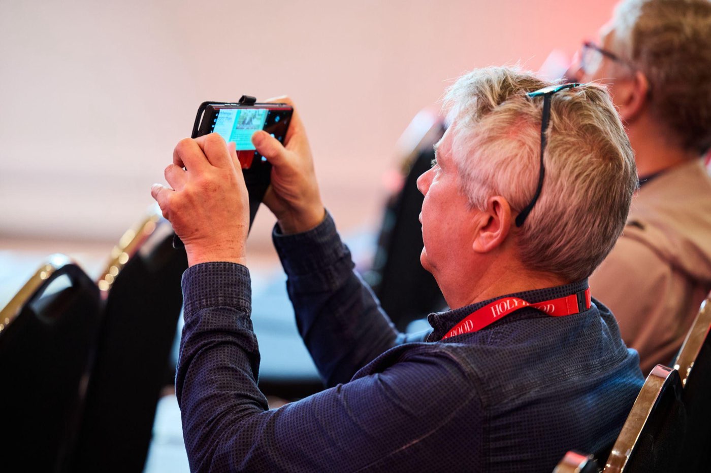 An attendee photographing a poll slide at the Holyrood Connect Digital Transformation event